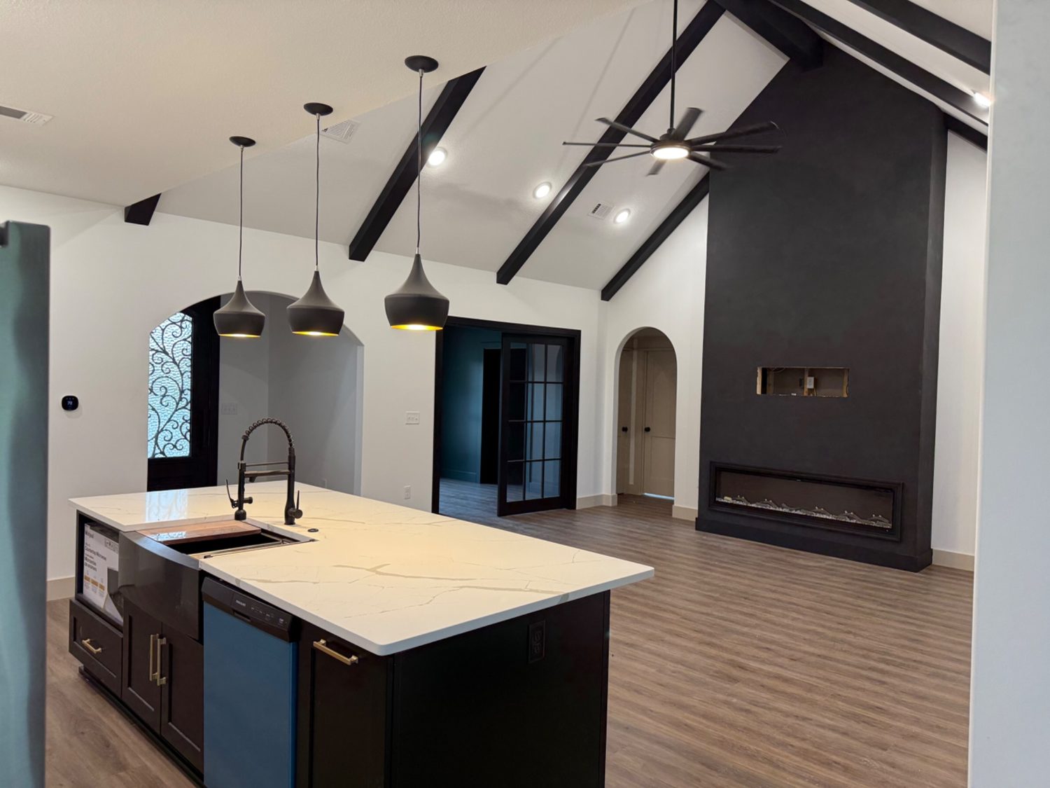 Finished open kitchen and vaulted living room with dark fireplace