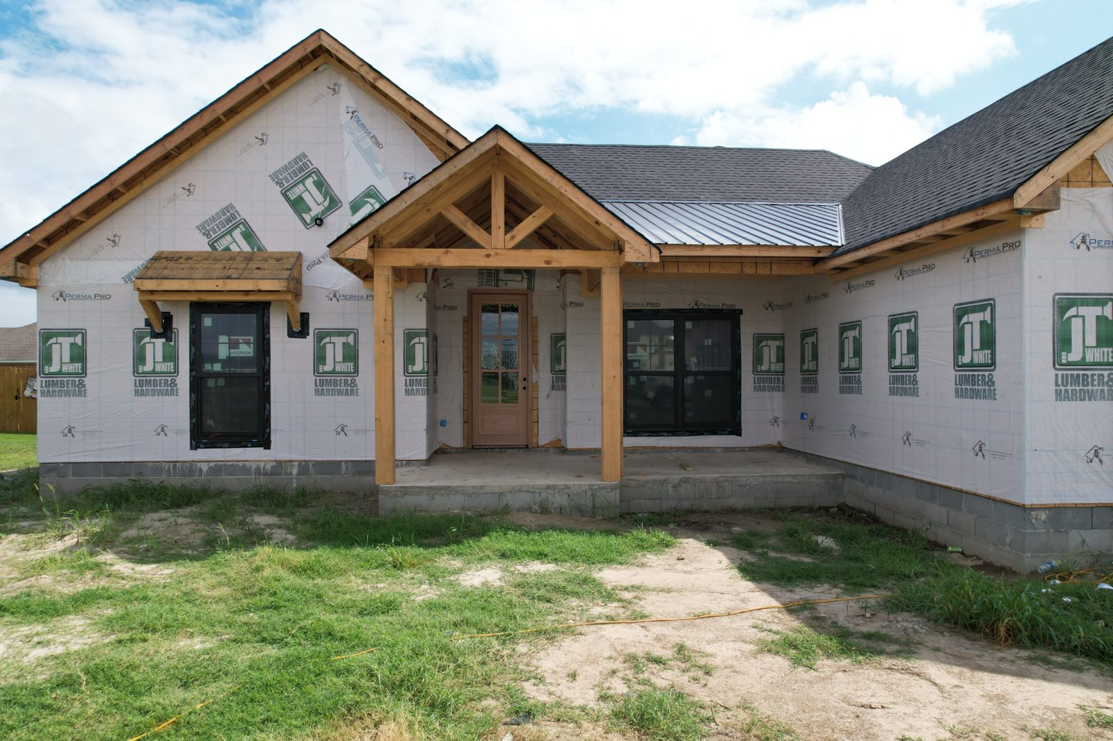 House wrapped and roofed with timber porch framing
