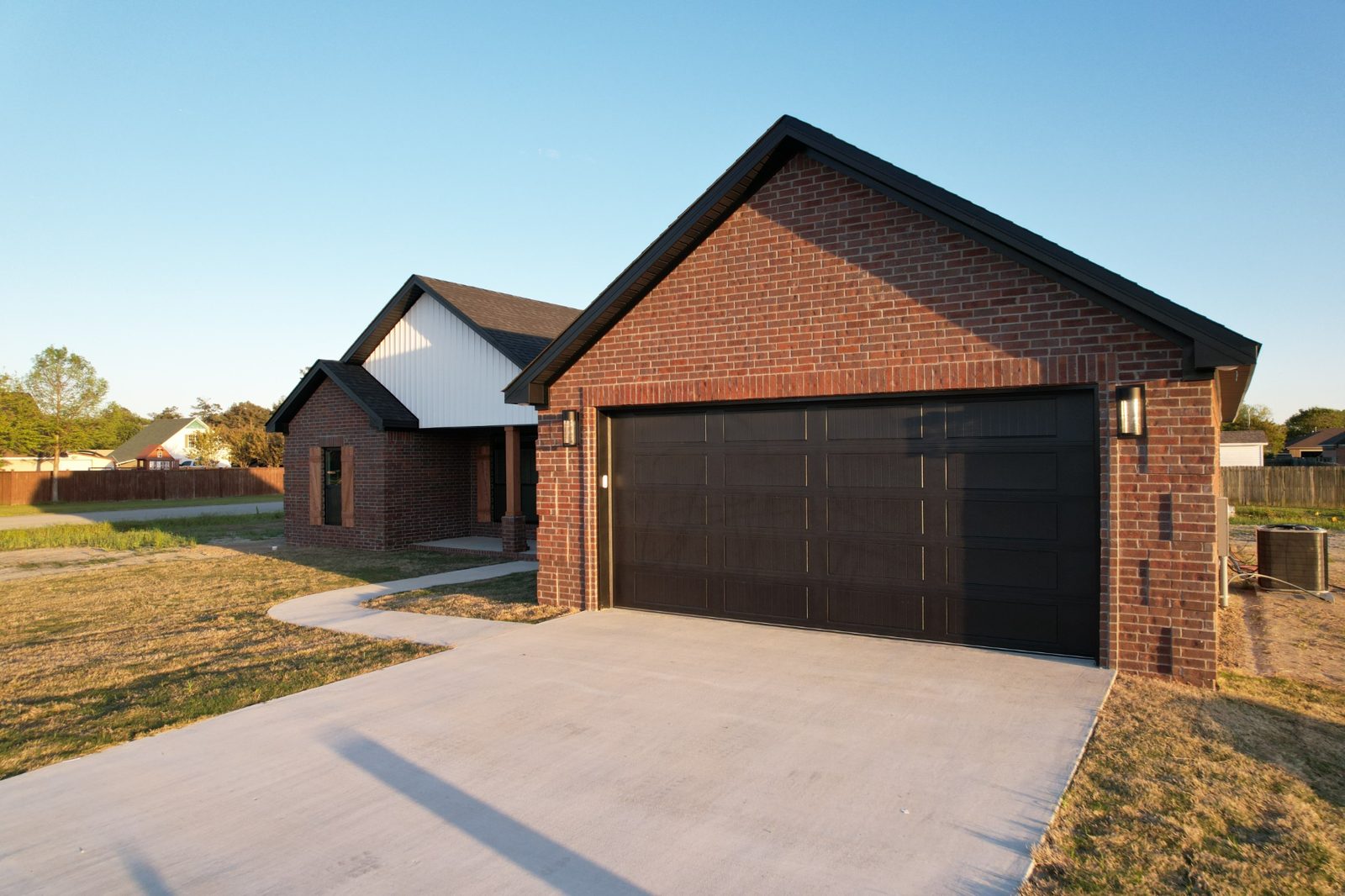 Finished red brick home with dark garage doors