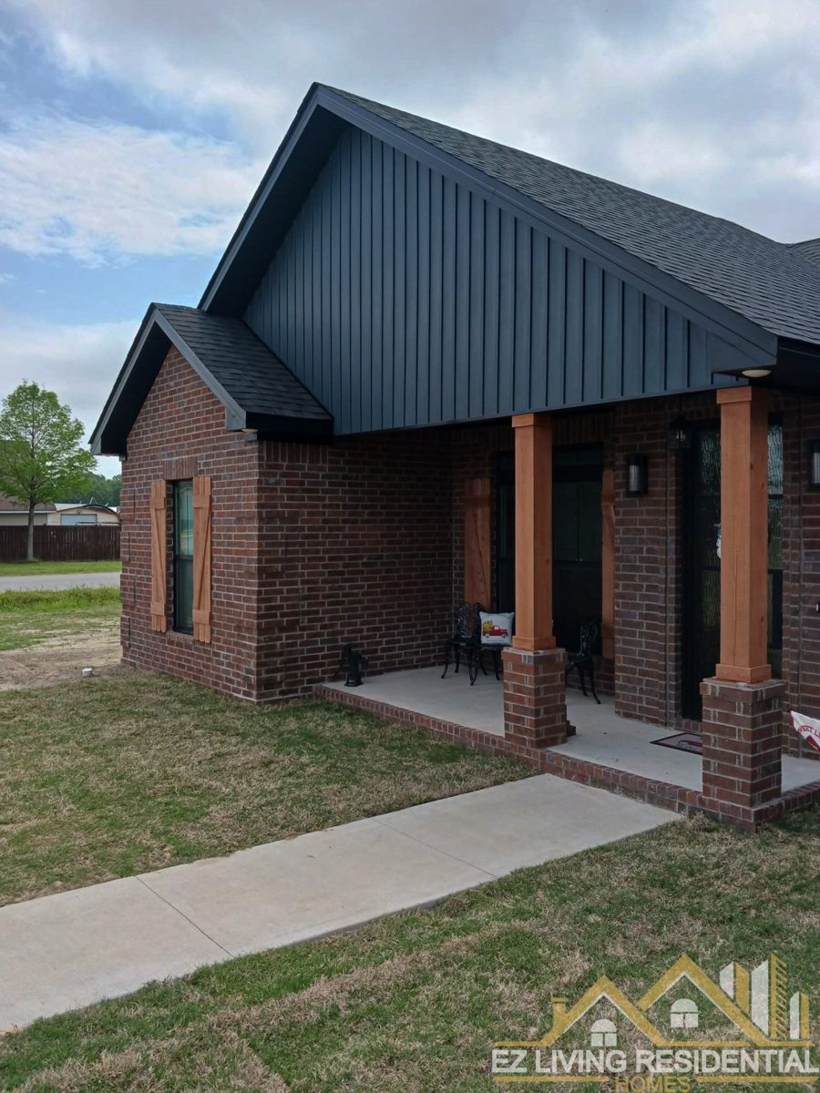 Covered rear porch with brick columns and dark siding